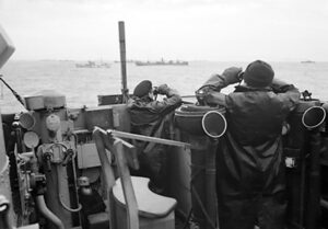 Officiers sur la passerelle d'un destroyer, qui escorte un grand convoi de navires, surveillent attentivement les sous-marins ennemis qui attaquent pendant la bataille de l'Atlantique. 