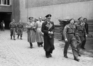 Karl Donitz suivi des ministres du gouvernement de Flensbourg, Alfred Jodl (en uniforme à gauche) et Albert Speer (en civil derrière Dönitz) lors de leur arrestation le 23 mai 1945
